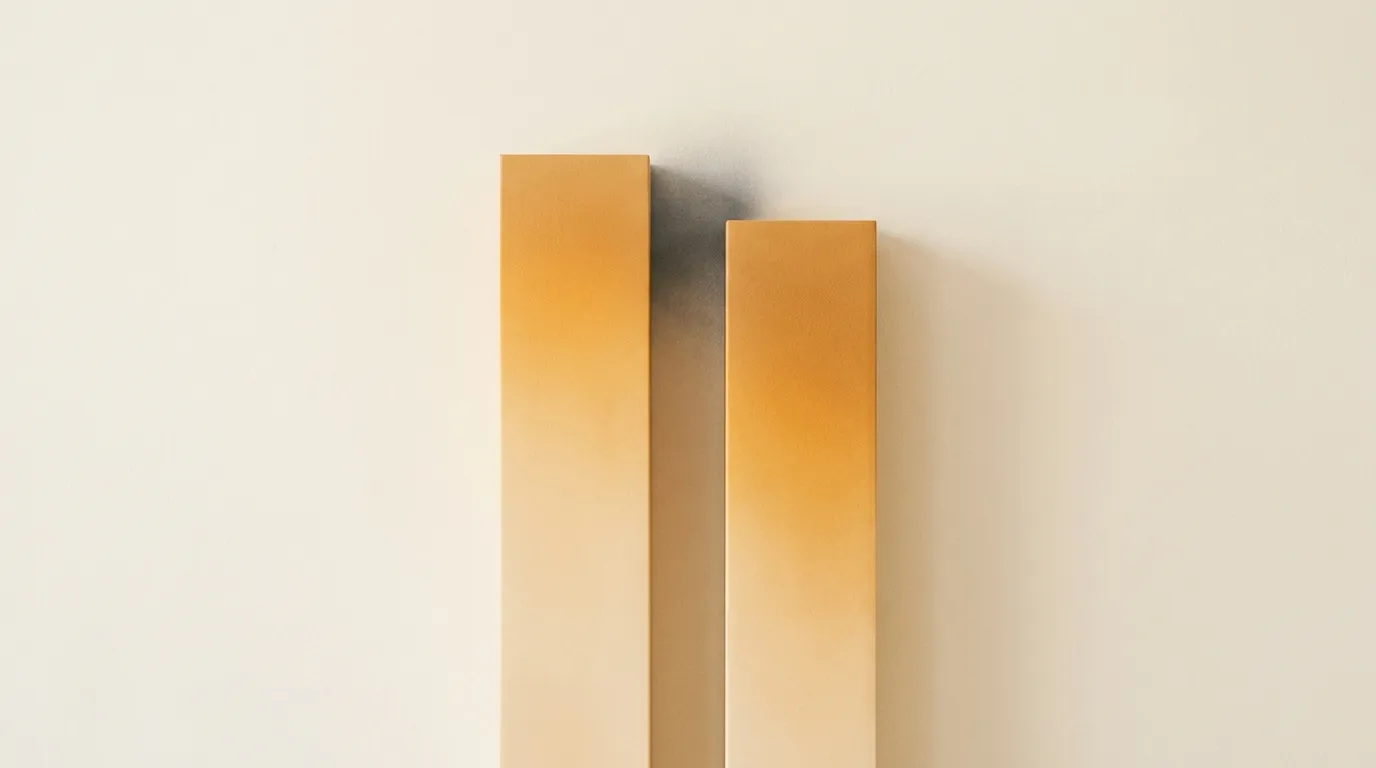 Two tall golden columns rising from cream, one almost imperceptibly shorter than the other, with the small gap between them shaded in charcoal